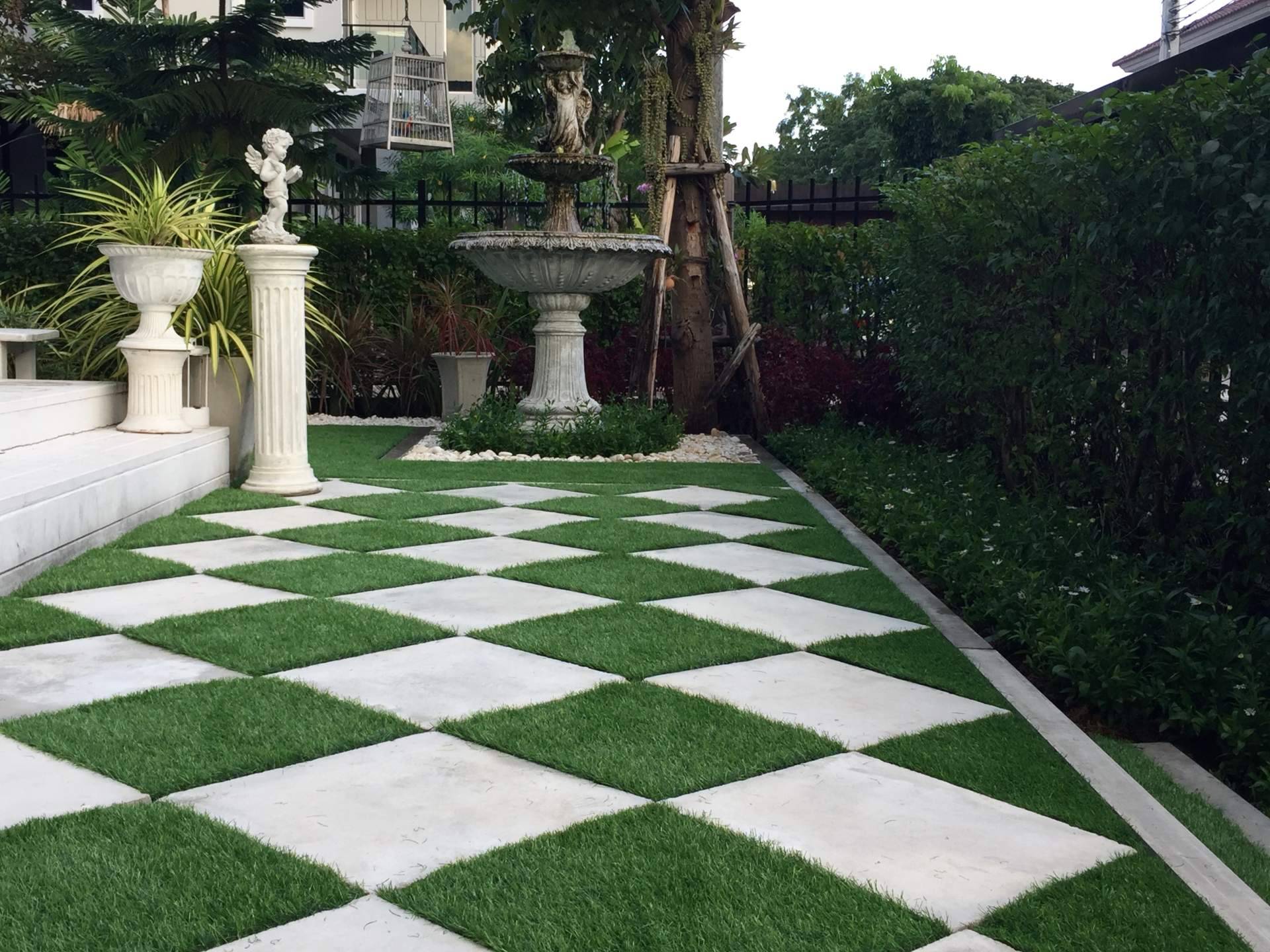 Decorar terrazas con jardines con piedras blancas y césped artificial